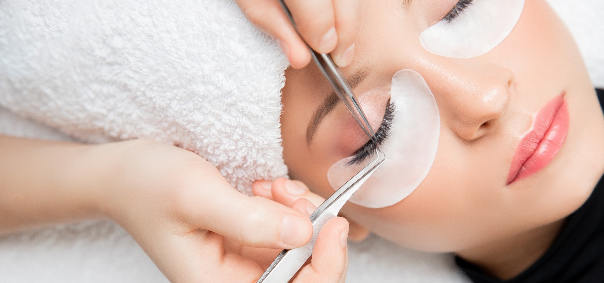 Eyelash extension procedure. Master tweezers fake long lashes beautiful female eyes